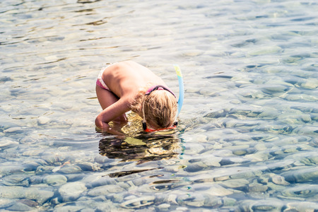 Girl looking down at bottom of seaの写真素材