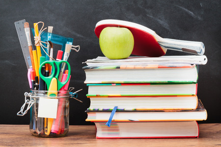 School accessories on desktop with blackboard in the backgroundの写真素材