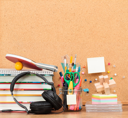 School accessories on desktop with blank pinboard in the backgroundの写真素材