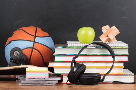 School accessories on desktop with blackboard in the backgroundの写真素材