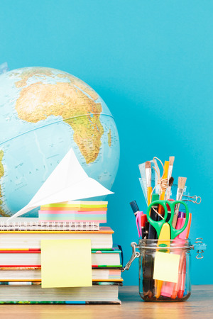 School accessories on desktop with blank blue backgroundの写真素材