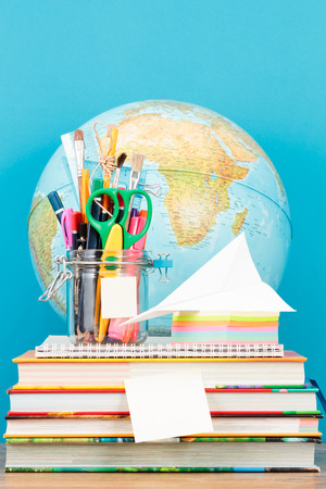 School accessories on desktop with blank blue backgroundの写真素材