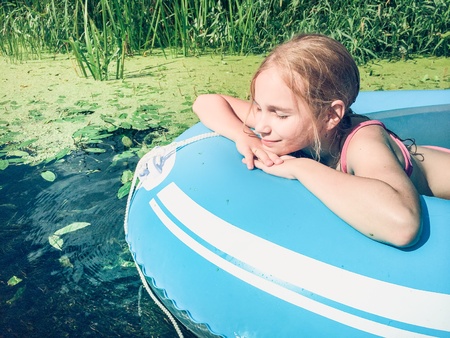 Little girl in a raft on a pure river.の素材