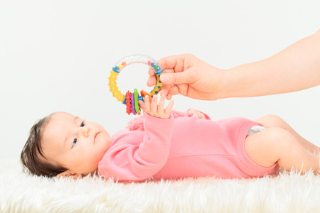 Mom giving a rattle her little baby girl. Copy space aboveの写真素材