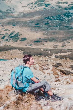 Boy resting on a mountain trailの写真素材