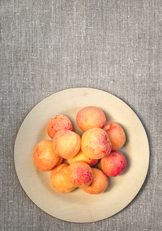Fresh apricots straight from the garden on wooden plateの写真素材