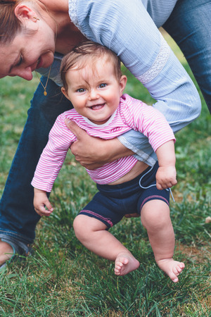 Mother playing with her little baby outdoorsの写真素材
