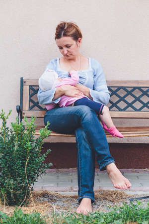 Mother breastfeeding her little baby outdoorの写真素材