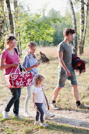 Happy family going on picnic  to forest on sunny day in the summertimeの写真素材