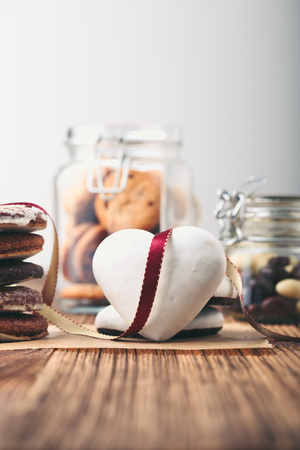 Gingerbread cookies, candies, cakes, sweets in jars on wooden table. Portrait orientationの写真素材
