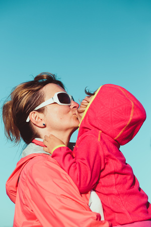 Love of mother and daughter. Mother hugging with her little daughter outdoors. Having fun, enjoying summer vacationsの写真素材