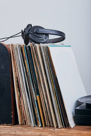Stack of many black vinyl records, turntable vinyl player and headphones put on the stack. Classic stereo set. Candid people, real moments, authentic situationsの写真素材