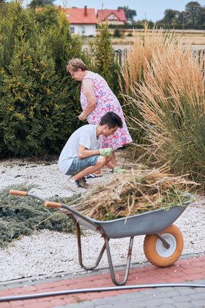 Grandchildren helping grandmother at a home garden. Candid people, real moments, authentic...