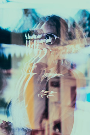 Reflection in a window glass of woman which is talking on her mobile phone. Real people, authentic...