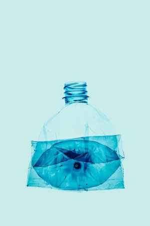 Empty plastic squashed bottles over blue background. Collecting plastic waste to recycling. Concept...