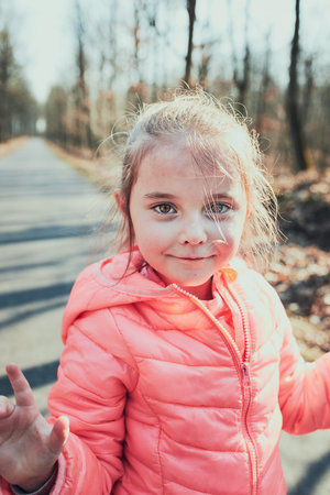 Portrait of little girl playing in the park, having fun on sunny autumn day. Real people, authentic...