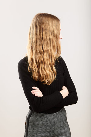 Portrait of profile long hair pretty cheerful young woman holding arms crossed standing over a grey...