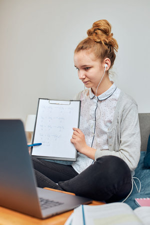 Young woman student having classes, learning online, watching lesson remotely, listening to...