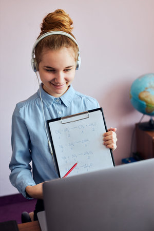 Young woman student showing homework, having classes, learning online, watching lesson remotely,...