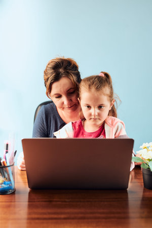 Little girl preschooler learning online solving puzzles playing educational games typing letters...