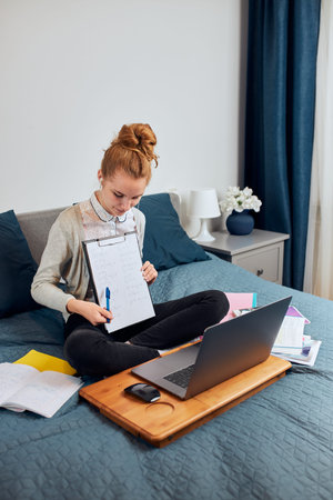 Young woman student having classes, learning online, watching lesson remotely, listening to...
