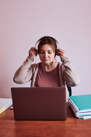 Woman working talking doing her job remotely during video chat phone call on laptop from home. Woman...