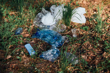 Plastic waste left in forest. Concept of plastic pollution and irresponsibility for environment. Environmental issue. Environmental damage. Real people, authentic situationsの写真素材