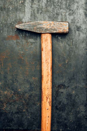 Old hammer on steel surface. Tool for maintenance. Hardware tool to fix. Technical background with copy spaceの写真素材