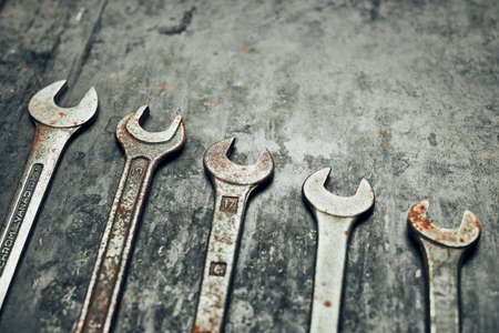 Spanners on steel surface. Old rusty wrenches for maintenance. Mechanic hardware tools to fix. Technical tools background with copy spaceの写真素材