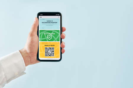 Digital covid certificate. Covid negative rapid digital test pass. Woman passenger holding digital medical pass on her mobile phone, passport and airplane ticket. Traveler showing digital covid test result as medical pass for travel during covid-19 pandemicの写真素材
