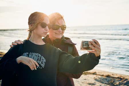 Happy women making video call on smartphone during trip on summer vacation. Taking selfie photosの写真素材