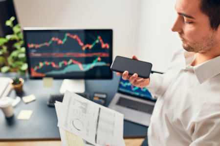 Businessman trading stocks online. Stock investor discussing numbers at graphs while phone...