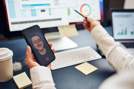 Woman entrepreneur having business video chat on smartphone with her business partner. Businesswoman...