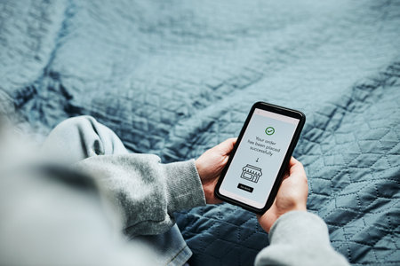 Woman buying product in online shop. Person paying using online mobile payment app. Customer ordering item in online store using smartphone. Online shopping from home. Order confirmation on screenの写真素材