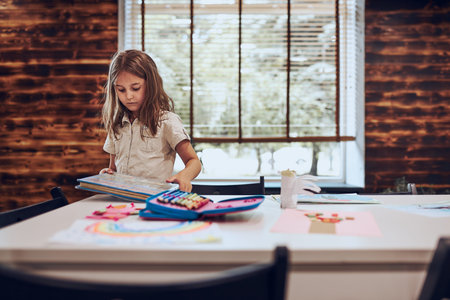 Girl doing homework, learning, drawing pictures, doing puzzles in school library. Primary school...