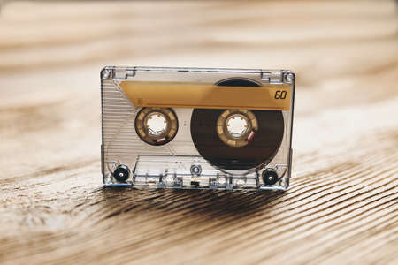 Tape cassette. Magnetic cassette tape on wooden table. Retro music style. 80s music party. Vintage style. Analog equipment. Stereo sound. Back to the pastの写真素材