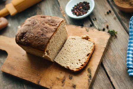 Rustic style whole grain bread loaf perfectly placed on a wooden cutting board. loaf of bread baked at home. Homemade baked goods. Healthy foodの写真素材