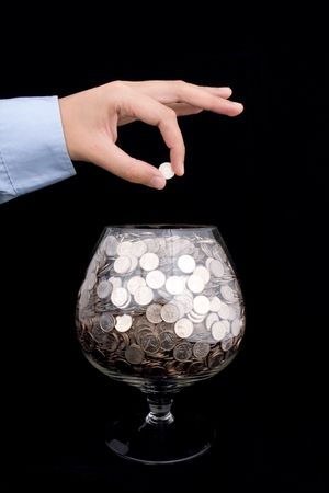 man's hand puts money into the glassの写真素材
