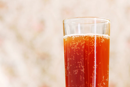 glass with carbonated drink on blurred background
