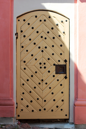 Closed wooden door in a stone house at sunriseの写真素材