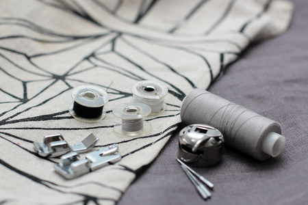 tools and accessories for sewing on a background of linen fabricの写真素材