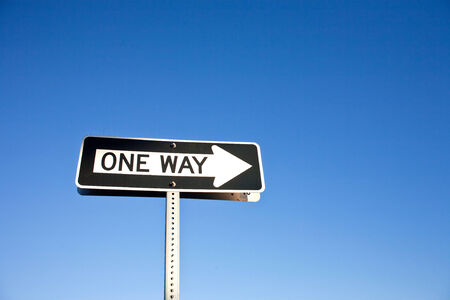 one way street sign with blue skyの写真素材