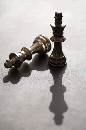 2 king chess figures, one stands, one downsの写真素材