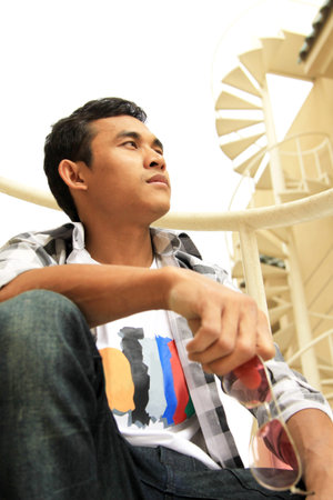 Asian guy setting on the stairs