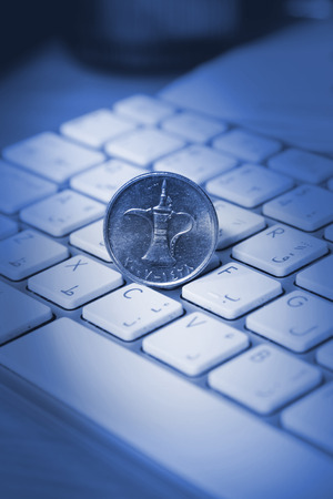 online transaction concept - one dirham on top of keyboardの写真素材