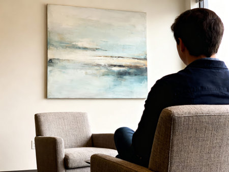 Man looking at a painting on the wall in the living room.の素材