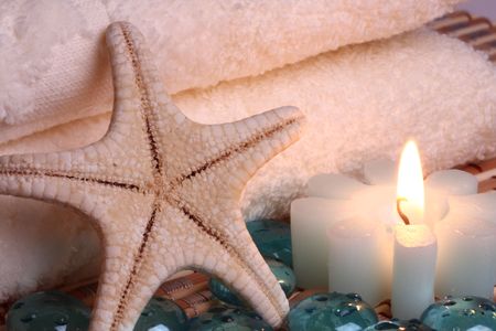 bath towels, candle, starfish and glass pebbles の写真素材