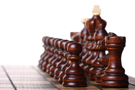 Wooden chess pieces on a chess board ready to battle. Isolated on white, shallow DOF