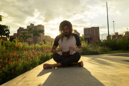 Man playing the drum in the park at sunsetの写真素材