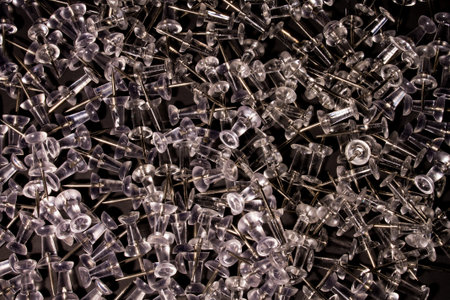 Hundreds of thumb tacks scattered on a black backdrop
